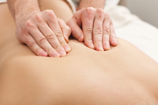 Closeup of hands massaging female back